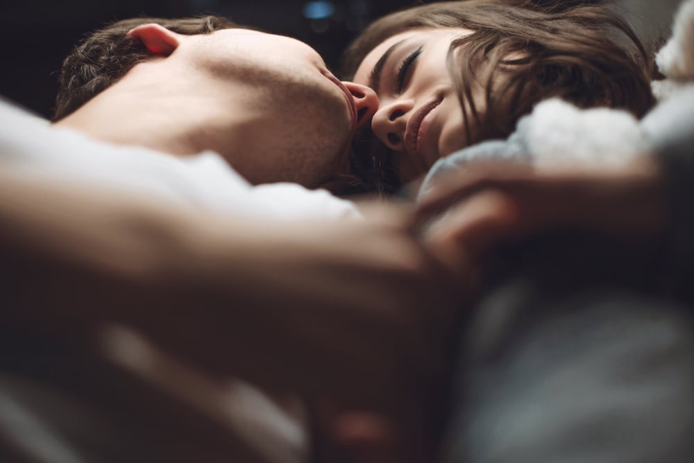 couple laying in bed after being intimate